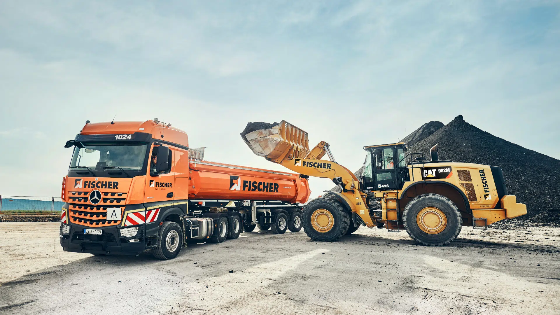 CAT 982M Radlader von Fischer belädt Fischer-LKW mit Material.