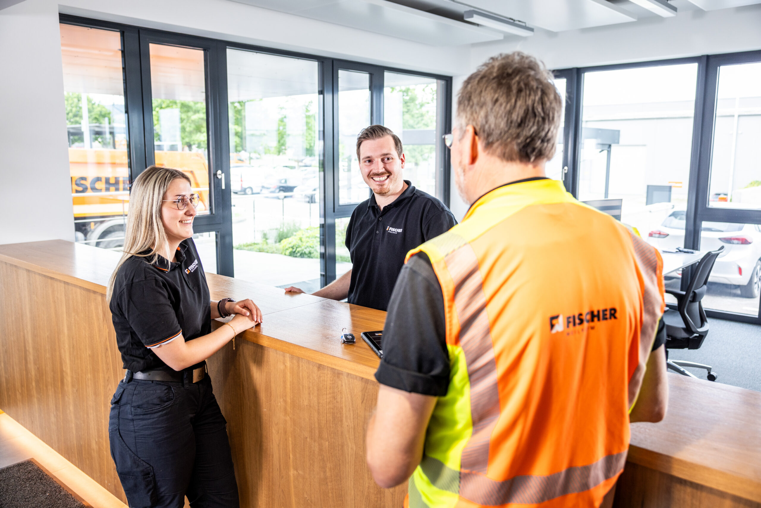 Drei Mitarbeiter sprechen miteinander an der Theke der Disposition