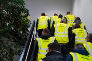 Gäste in Besucher-Warnwesten auf dem Weg zum Rundgang beim FISCHER Lunch 2026